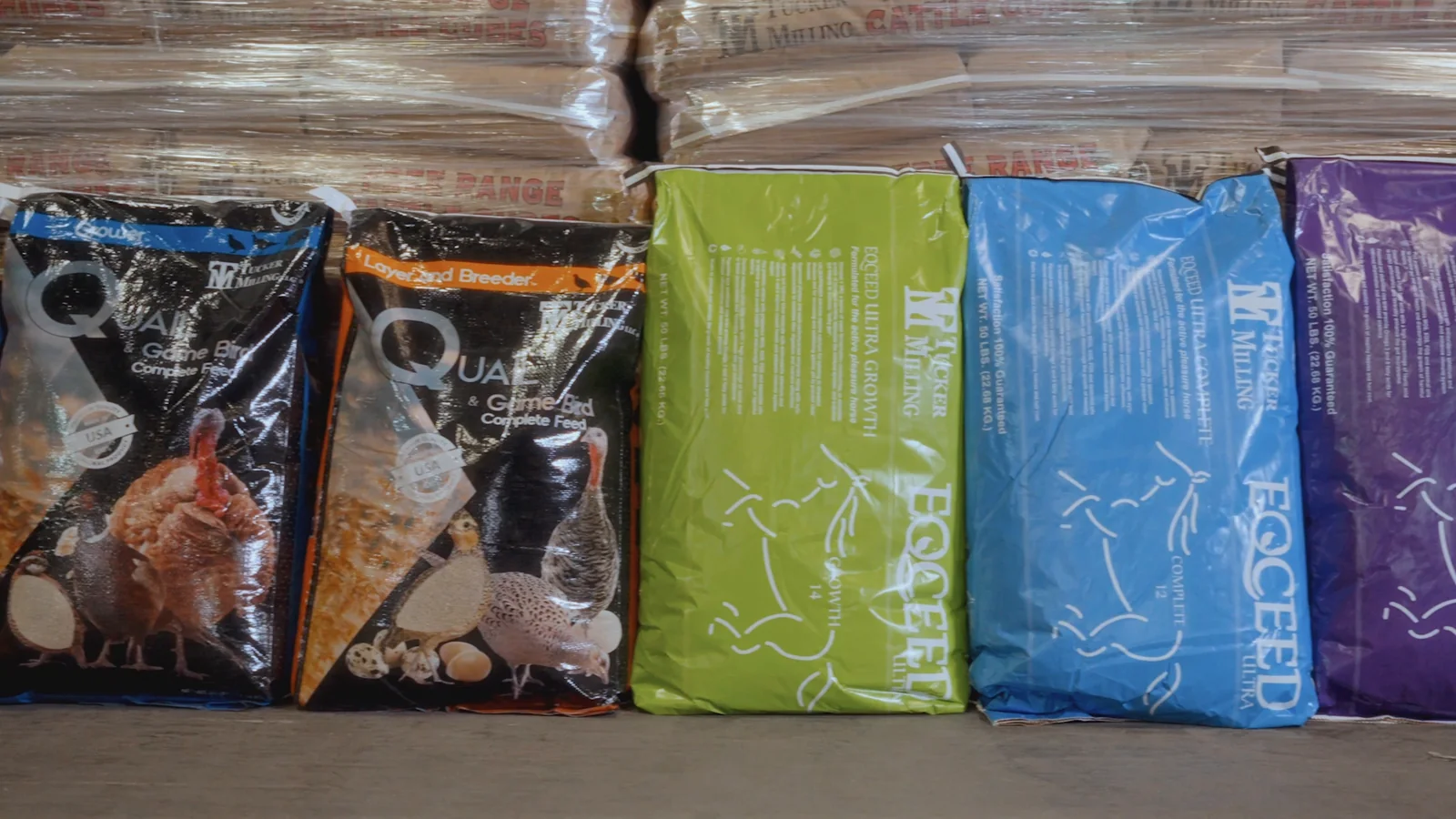 Tucker Milling feed bags lined up in front of wrapped pallets of feed